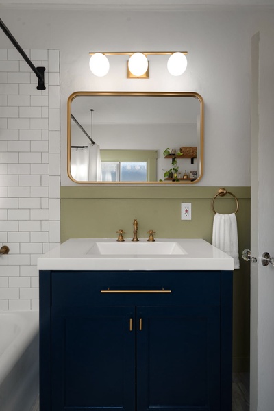 Refresh with ease in this bright bathroom featuring brass accents and subway tile details.