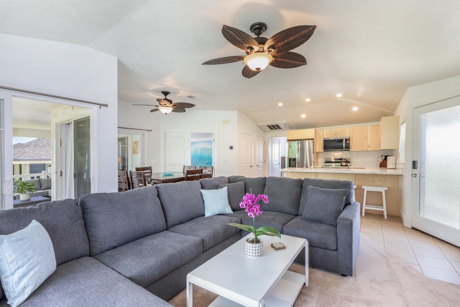Comfortable living room with ample seating and ceiling fan.