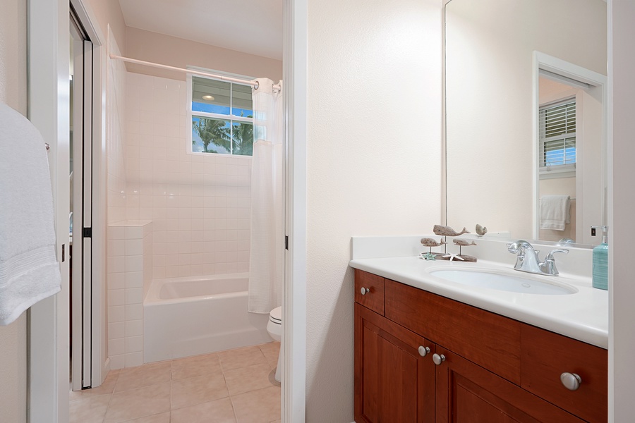 Shared bathroom with a shower/tub combo.