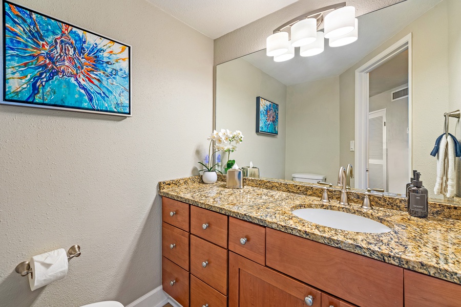 This bathroom offers a spacious granite countertop and a bright, modern design for a refreshing start to your day.