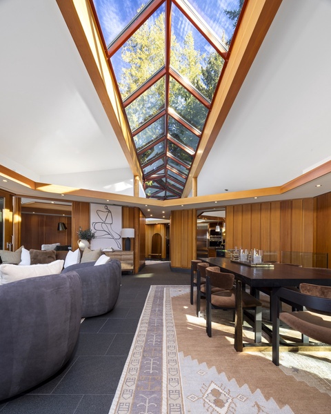 Natural light floods your open living space through the stunning glass ceiling, creating warmth while you relax or dine.