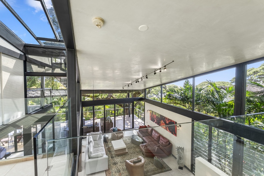 Floor-to-ceiling windows fill the space with natural light and lush rainforest views.