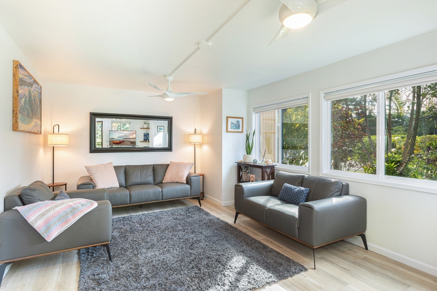 Bright, welcoming & comfortable living room with large windows and garden views—perfect for relaxing after beach days.
