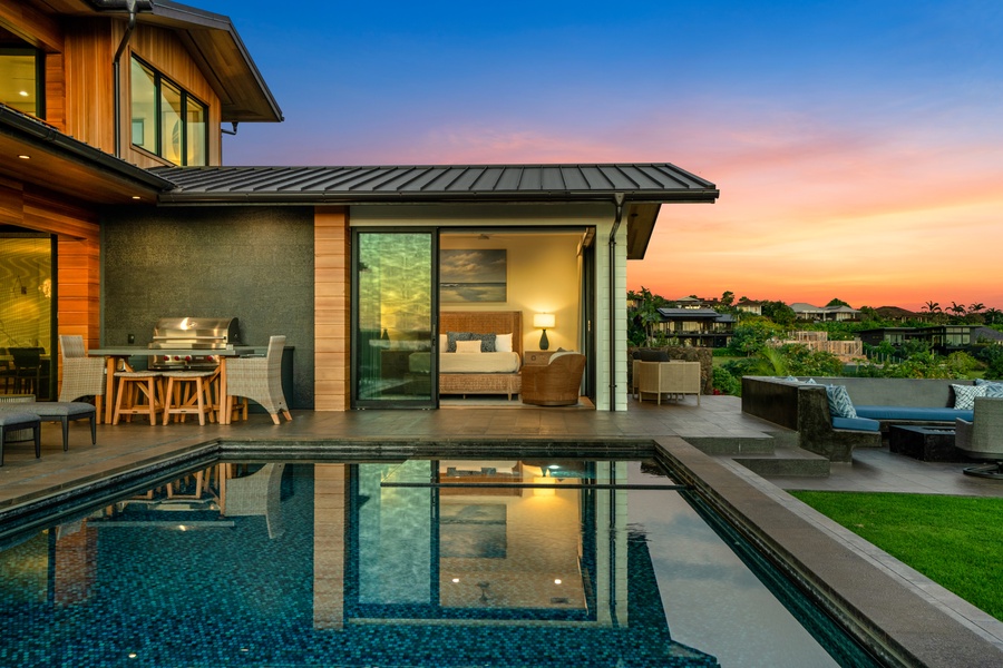 Modern luxury villa showcases stunning architecture with pool area against a vibrant sunset sky backdrop.