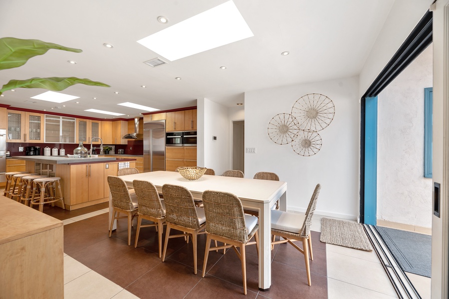 Large open kitchen with bar seating and dining table for 10