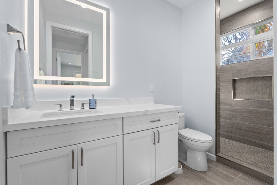Full bath with expansive vanity, LED mirror, and under-cabinet storage—a blend of function and elegance.