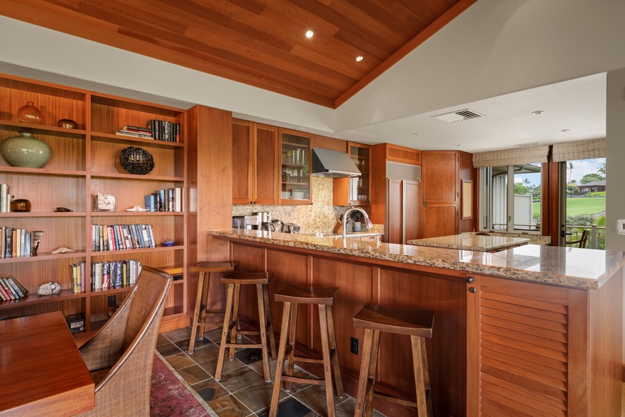 Four bar seats line the countertop, perfect for conversation with the chef during meal prep.