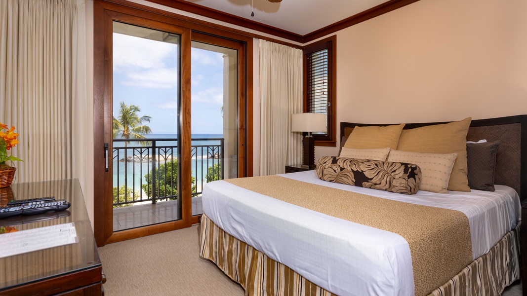 The primary guest bedroom with access to the lanai and views of the sea.