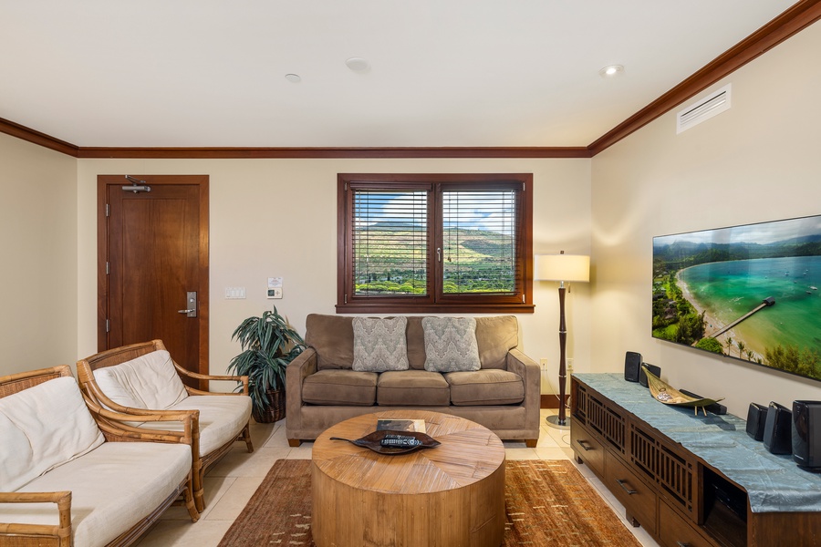 Unwind in your spacious living room with comfortable seating, warm wood accents, and beautiful countryside views through large windows.