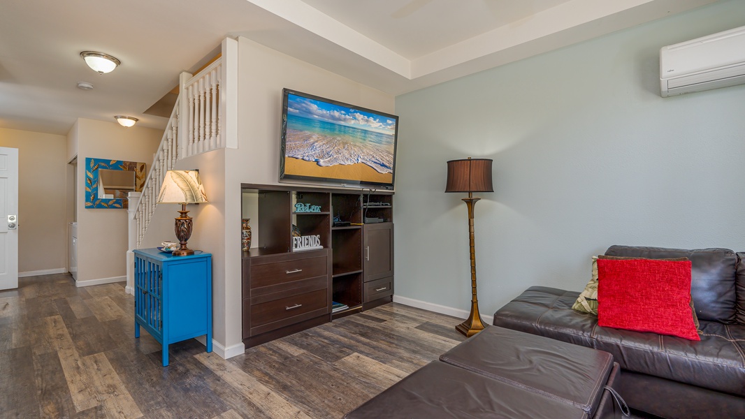 Unwind in your stylish living space with plush leather seating, vibrant coastal decor, and entertainment center for cozy evenings at home.