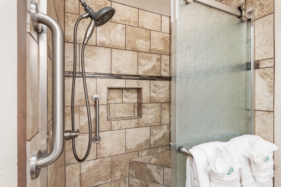 Step into a warm, inviting shower with elegant tilework and a glass enclosure – perfect for unwinding after a day of island adventures.