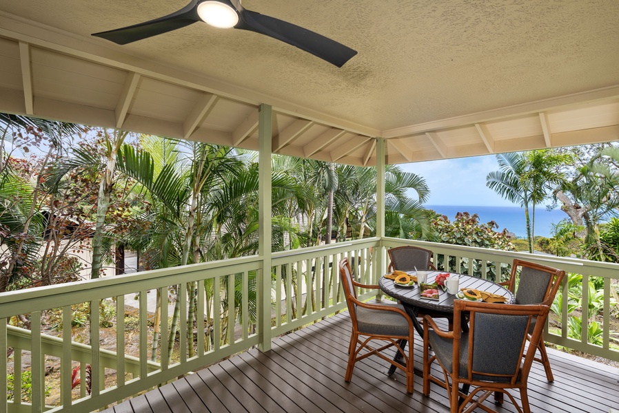 Enjoy your morning coffee on this covered lanai in Hale Joli Ohana where lush tropical gardens frame distant glimpses of the ocean.
