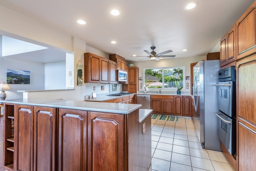 Wide and open, fully-equipped kitchen with stainless steel appliances