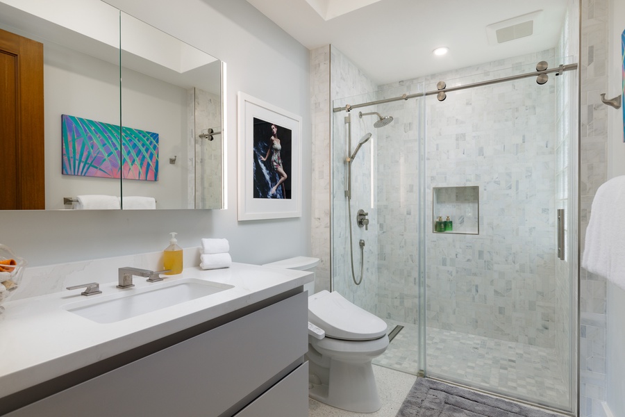 Ensuite bathroom with a walk-in shower and sleek glass design for modern comfort.
