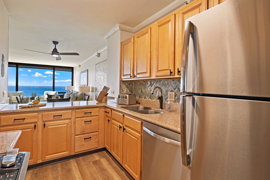 The kitchen at Mahana 718 connects seamlessly to the living area, with stunning ocean views.