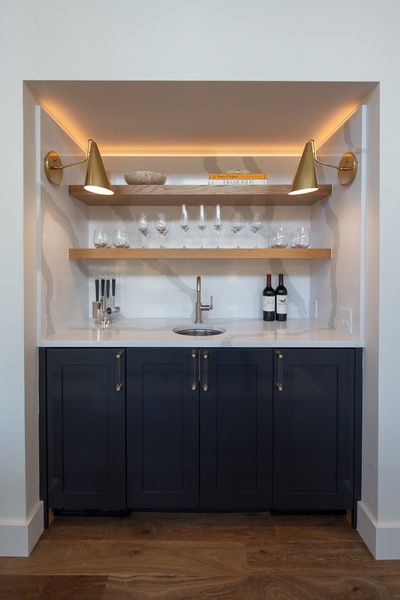 Sophisticated mini-bar nook with elegant glassware and warm lighting—perfect for evening relaxation and entertaining guests.