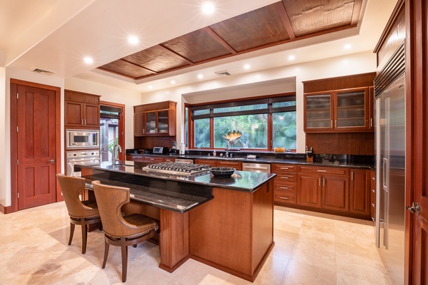 Spacious kitchen with rich wood cabinetry, a large central island, and ample counter space, perfect for preparing meals and entertaining guests.