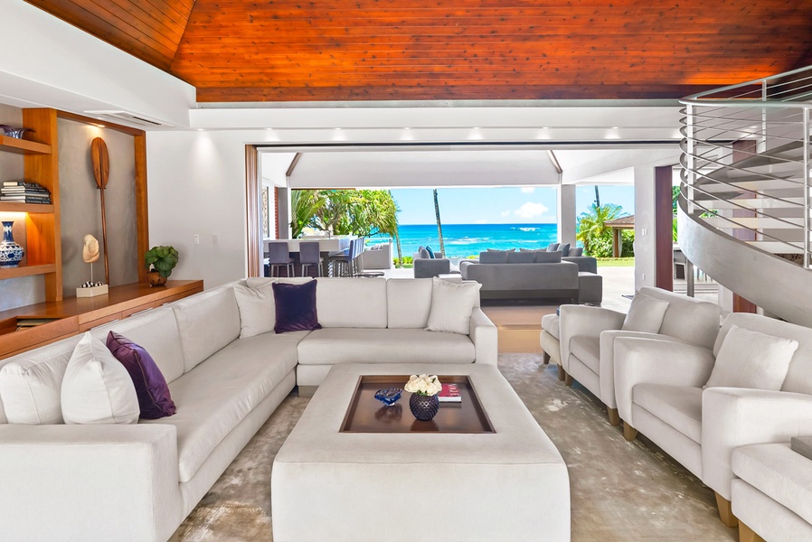 Sink into plush seating beneath a stunning wood ceiling while the turquoise Caribbean beckons just steps away through open-air living spaces.