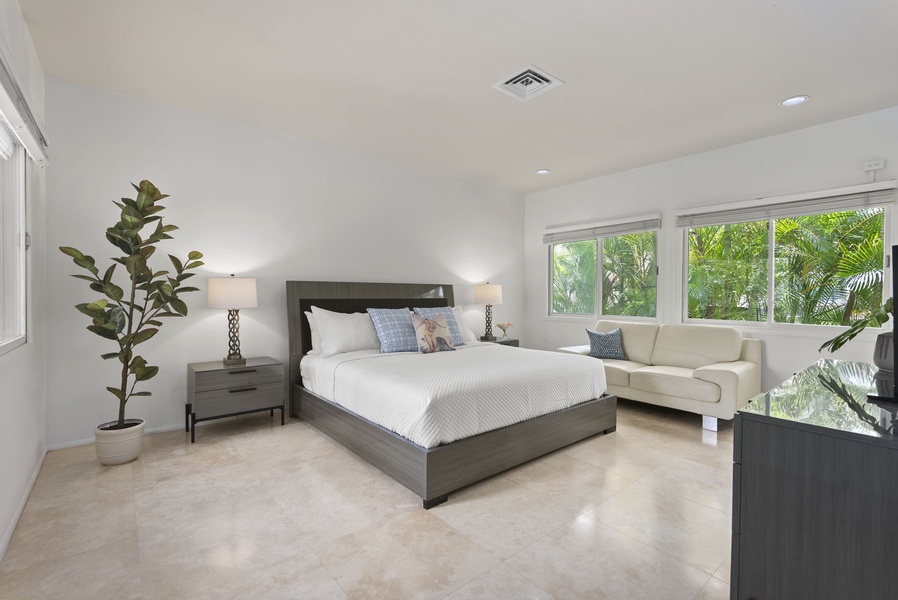 This sunlit guest bedroom features clean lines, a king-size bed, and garden views—ideal for extended stays.