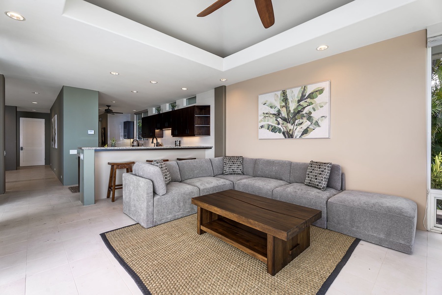 Sink into your plush sectional sofa while the stylish kitchen beckons for morning coffee or evening cocktails in this airy, modern home office.