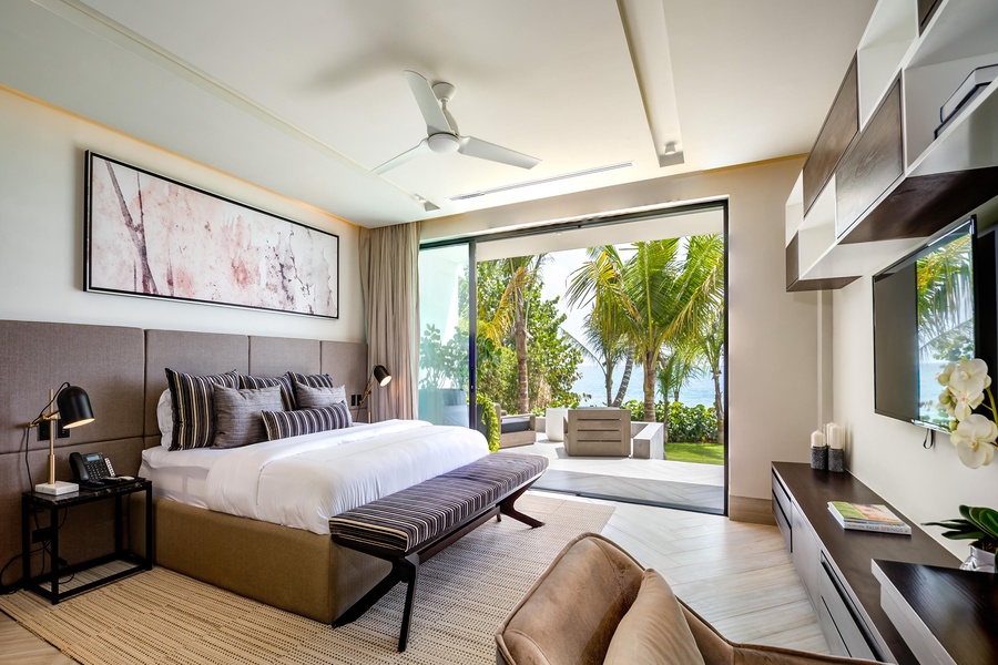 The guest bedroom with a cozy bed, modern furnishings, and direct access to a private outdoor seating area.