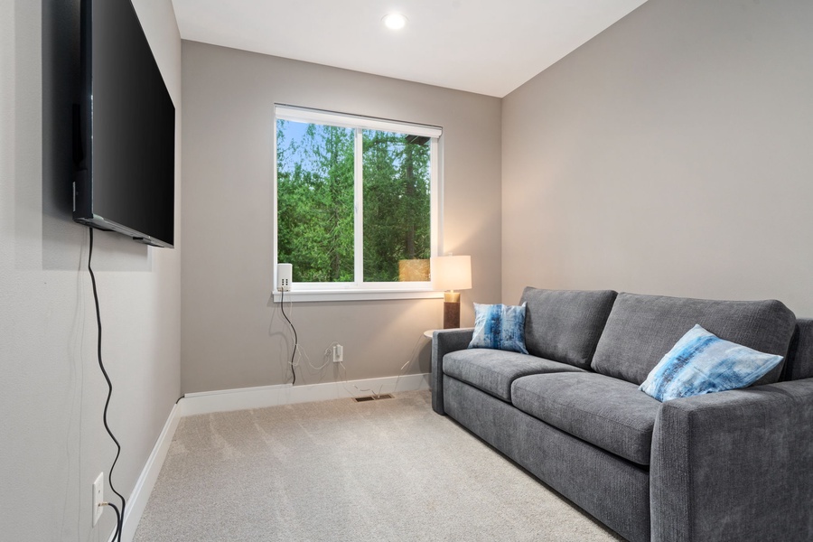 Cozy fourth bedroom with a comfortable queen sleeper sofa and soft, neutral tones.