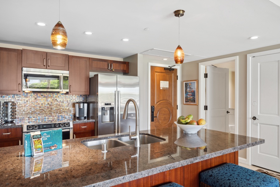 Honua Kai Konea 204 features a chef-ready kitchen with cherry cabinetry and stainless steel appliances.