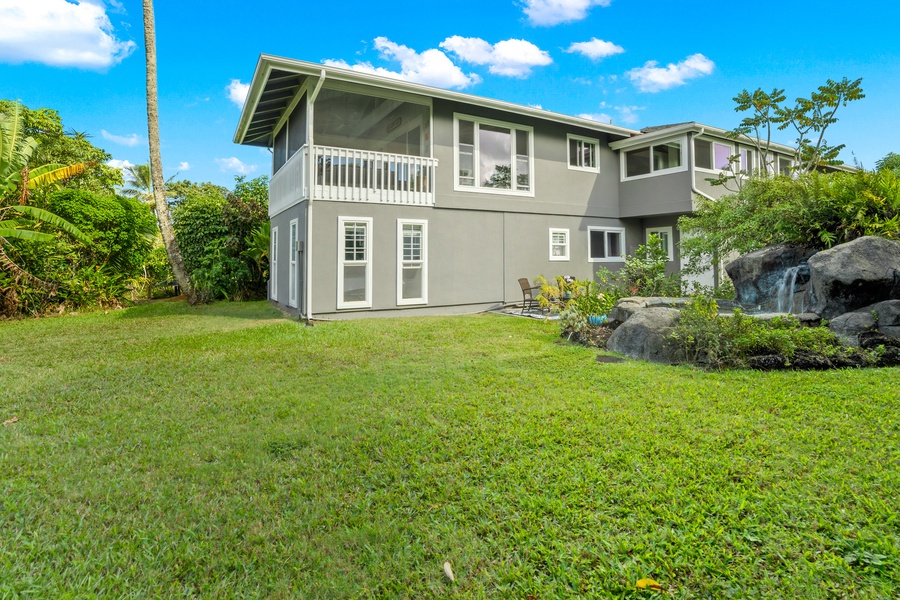 Spacious backyard with a well-maintained lawn and a view of the home's elegant exterior, perfect for outdoor activities.