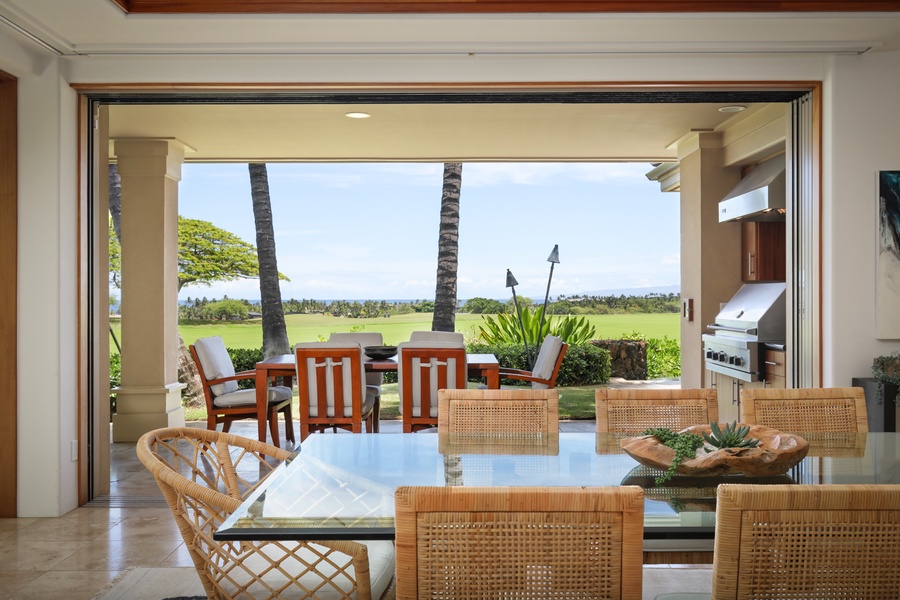 View from interior dining room to outdoor lanai (deck) dining area.