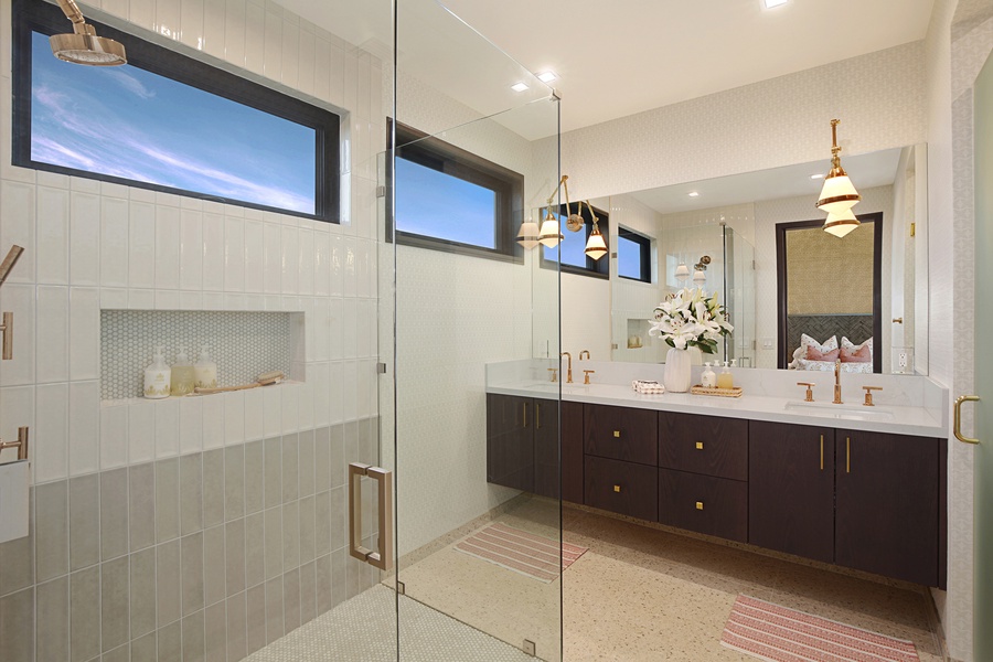Ensuite bathroom with a shower in a glass enclosure and two sinks.
