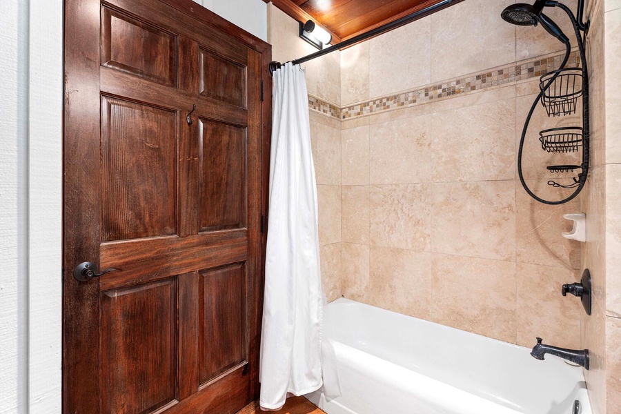 Spacious primary bathroom with tub and shower combo for your comfort.