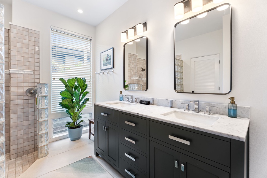 Double-sink vanity with custom cabinetry and abundant natural light, creating a private spa-like start or end to your day.