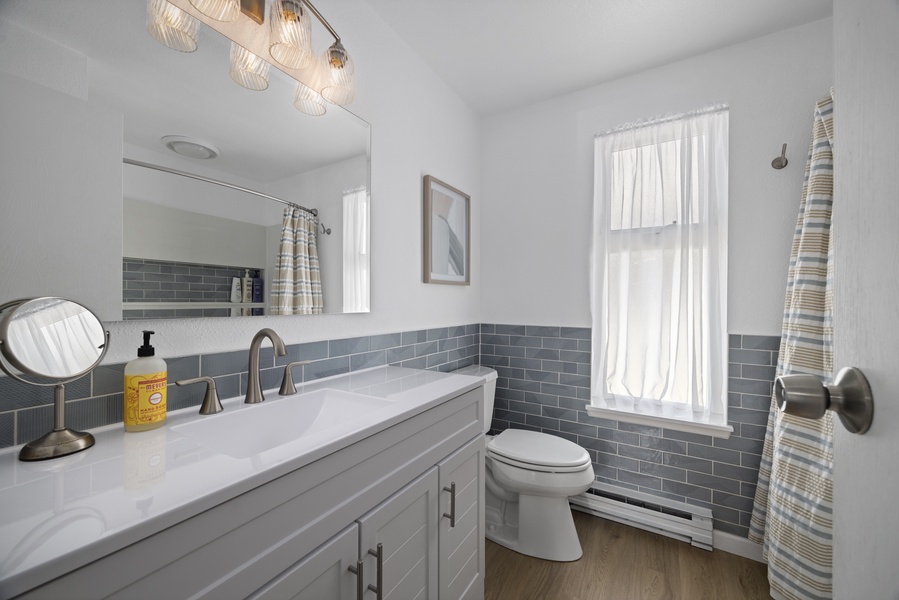 Bright and spacious guest bathroom with a full tub/shower combo and ample counter space.