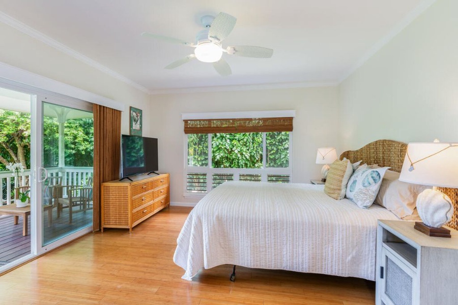 The primary bedroom has a Cal King bed, flat-screen TV, and a dresser, boasting a direct access to a private lanai