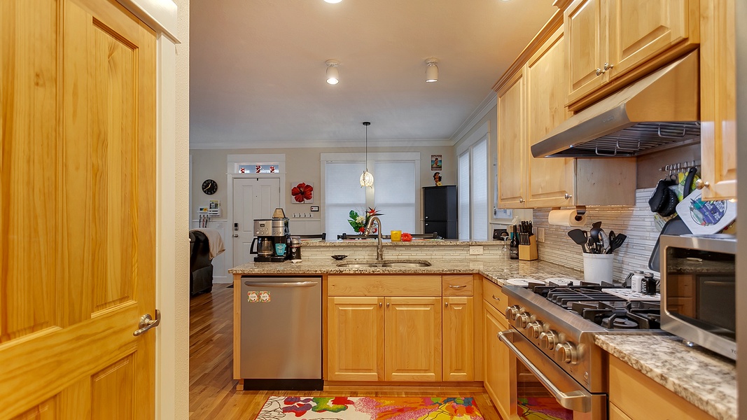 The kitchen is equipped with a coffee maker, dishwasher, oven, and stove top