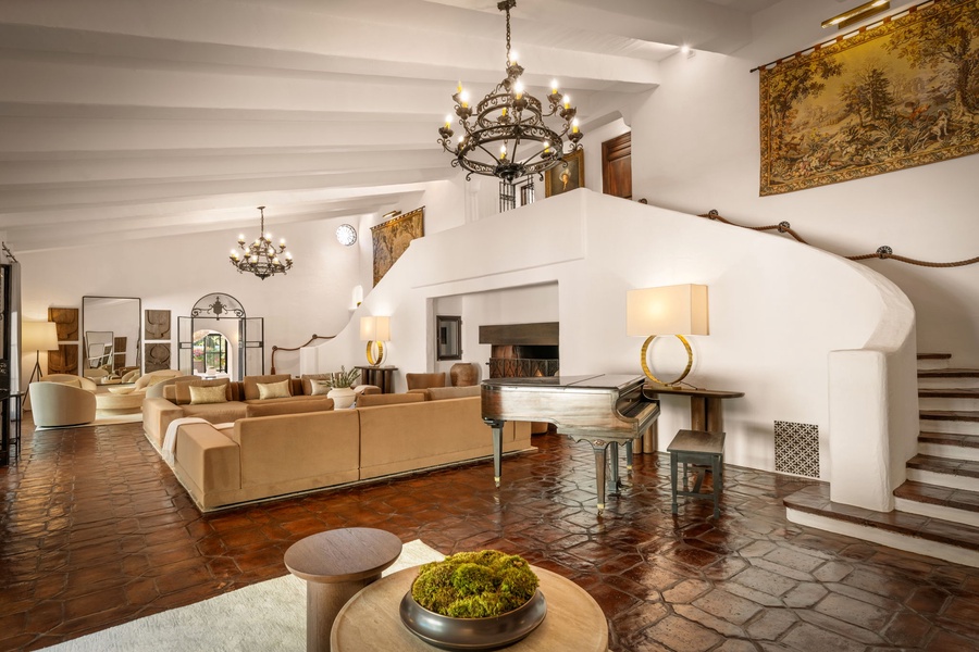 Terracotta floors, soaring ceilings, and wrought-iron chandeliers bring character and warmth to this inviting indoor gathering space.