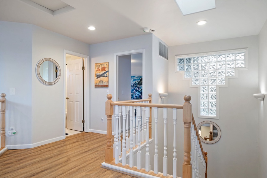 Step into your bright, airy hallway where natural light streams through glass block windows, creating a welcoming space to start each day.