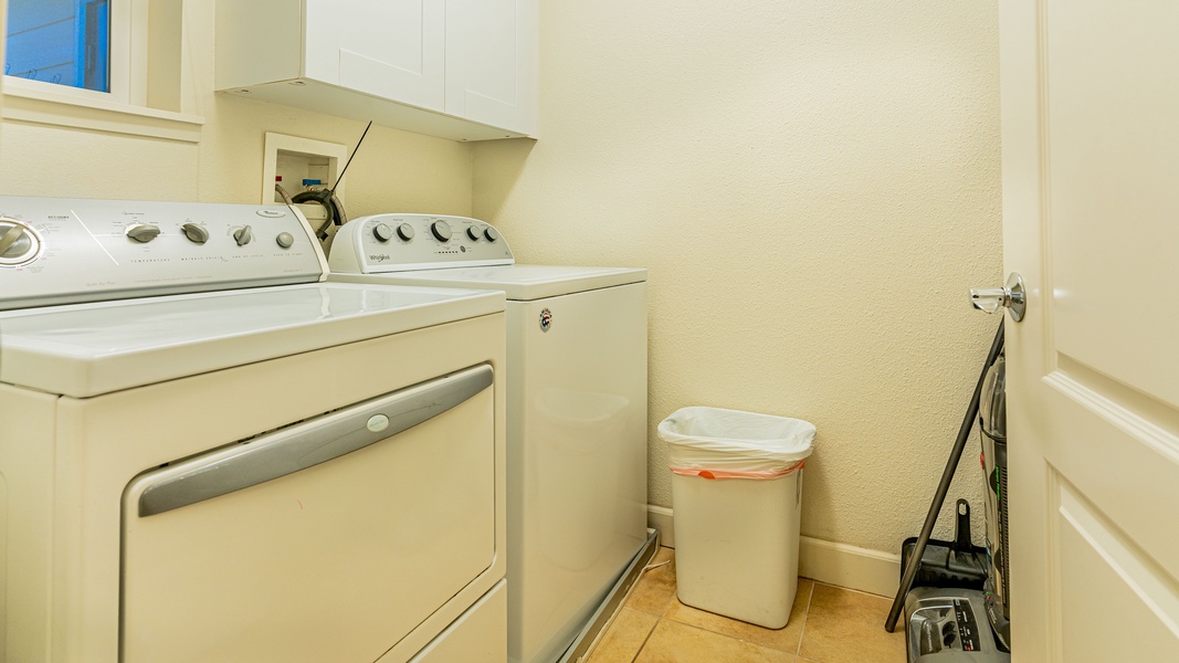 The laundry room with a washer, dryer and cabinet space.