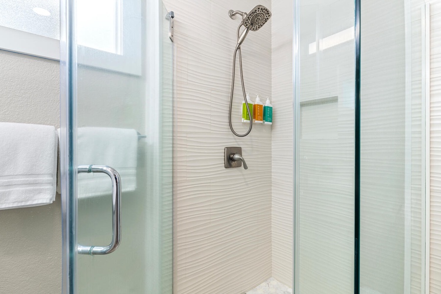 Walk-in shower with tiled walls and modern fixtures.