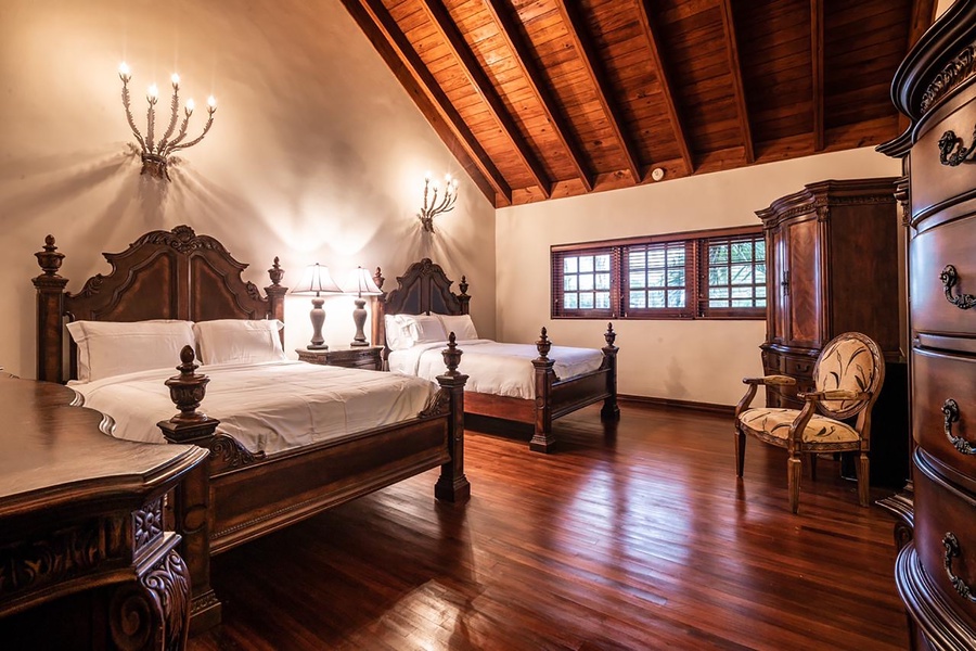 Charming guest bedroom with double beds and antique furniture, perfect for a restful night's sleep.