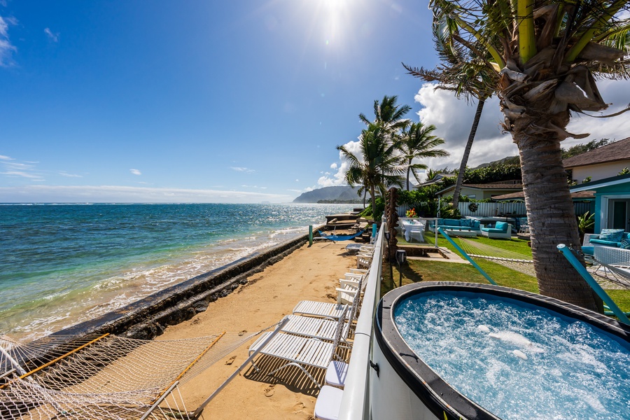 Beachfront home with sandy shoreline, ocean views, and tropical landscaping throughout.