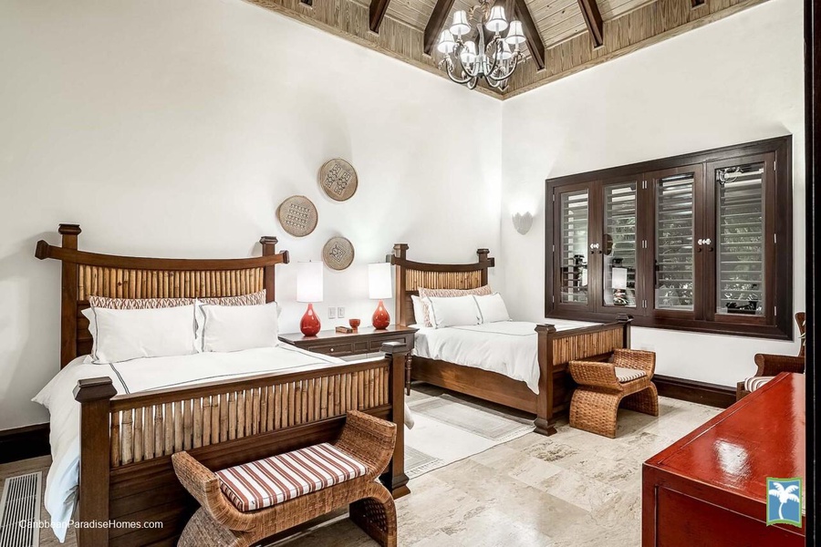 Inviting guest bedroom with wooden accents and beautiful high ceilings.