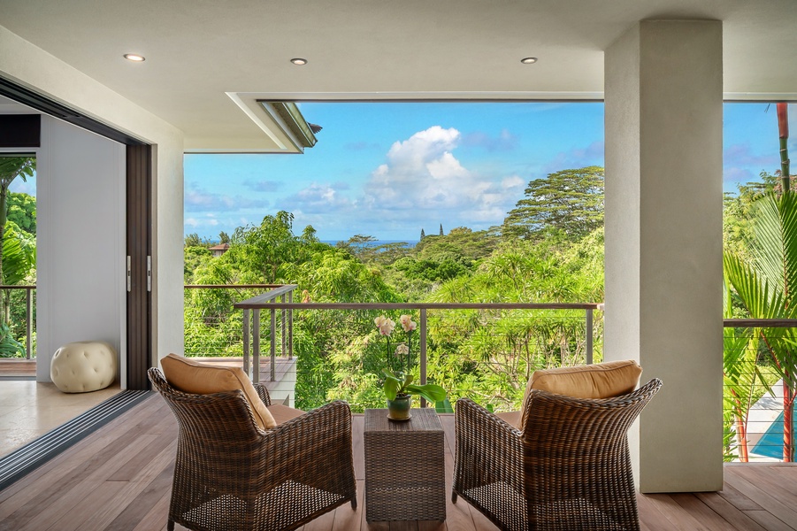 Private seating area on the lanai with breathtaking views of the lush landscape, perfect for morning coffee.