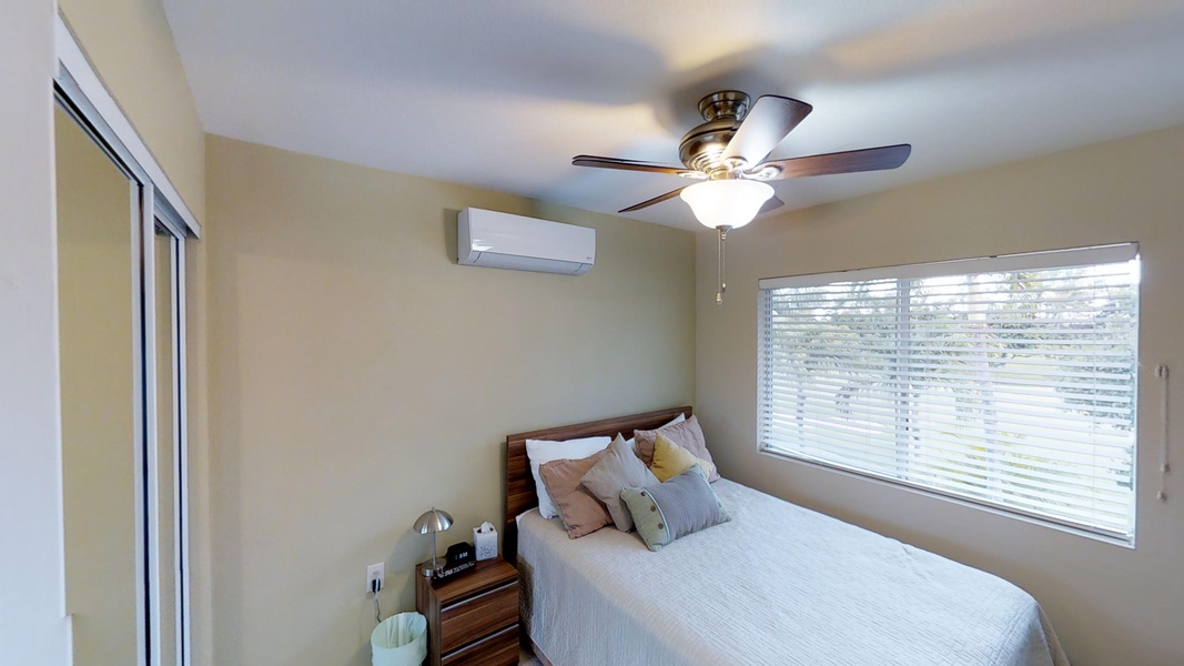 The second guest bedroom is well appointed with soft linens and decorative pillows.