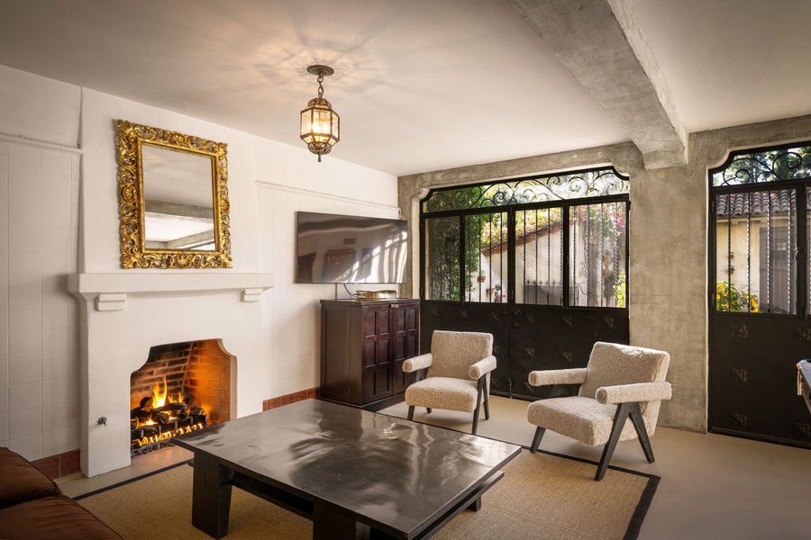 Cozy up by the crackling fireplace in this elegant living room, where warm light and thoughtful furnishings create your perfect retreat.