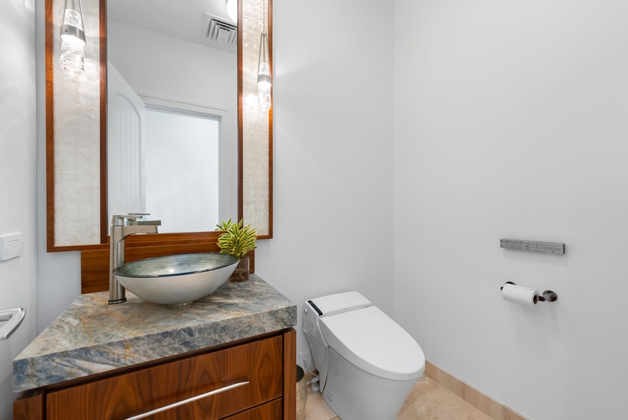 Powder room with elegant sink and mirror, perfect for guests and entertaining.