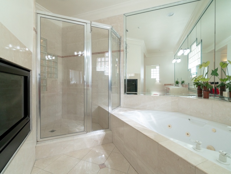 Shower room with glass enclosure right next to the bath tub