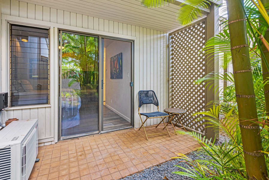 A cozy outdoor seating area just outside the bedroom, perfect for enjoying morning coffee or quiet moments surrounded by greenery.