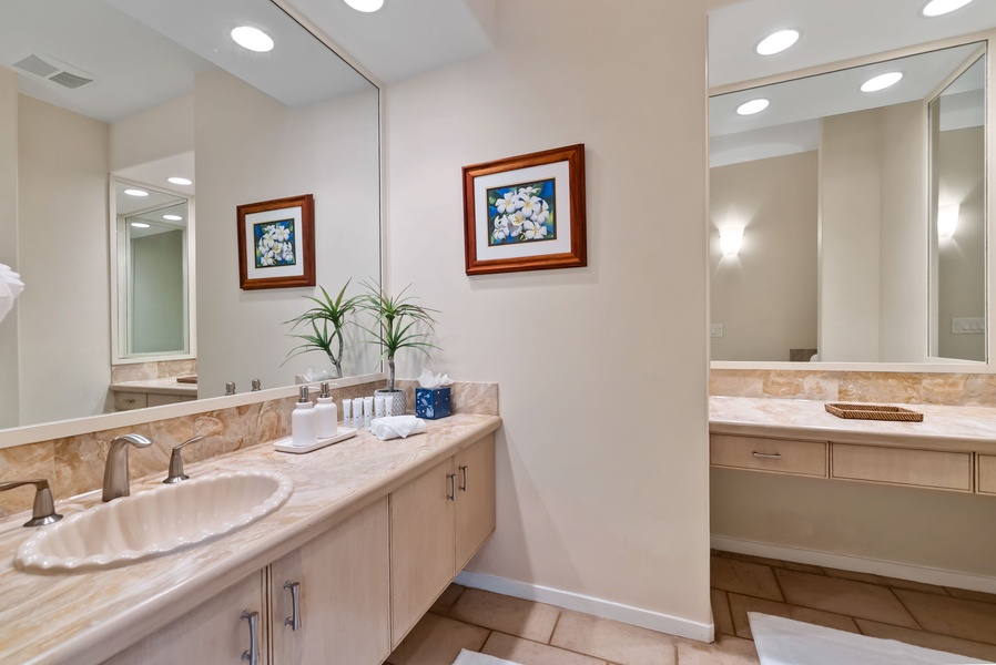 Pamper yourself in this elegant dual-vanity bathroom with marble countertops and thoughtful touches.