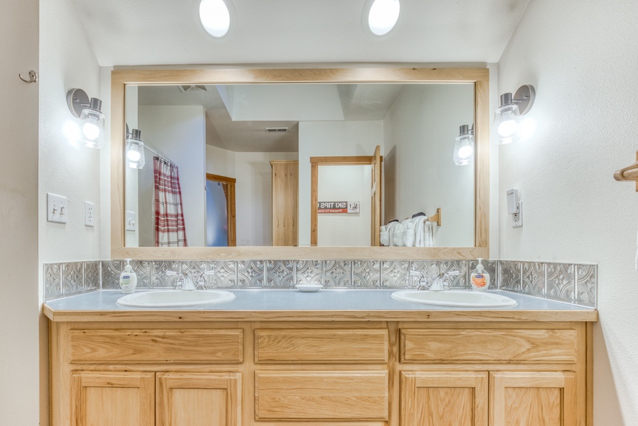 The guest ensuite bathroom has vanity with two sinks and storage.